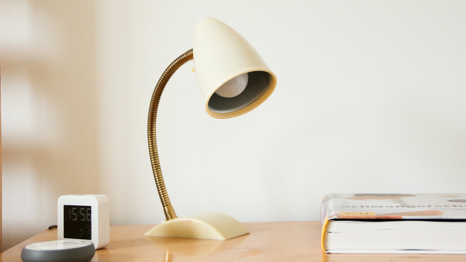 A warm desk lamp beside a stack of books